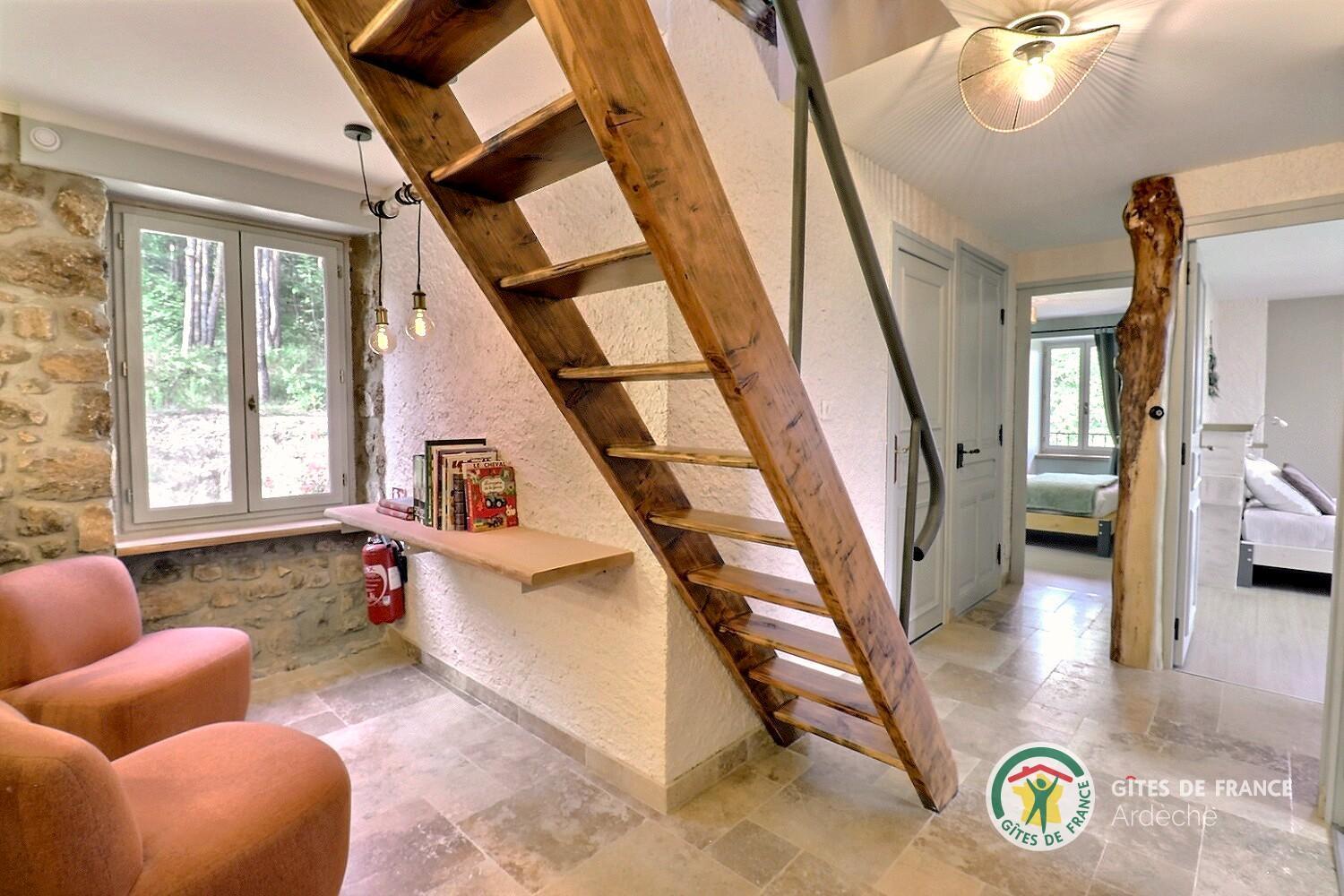 Escalier en bois desservant la pièce de vie du gîte, ouverte et lumineuse