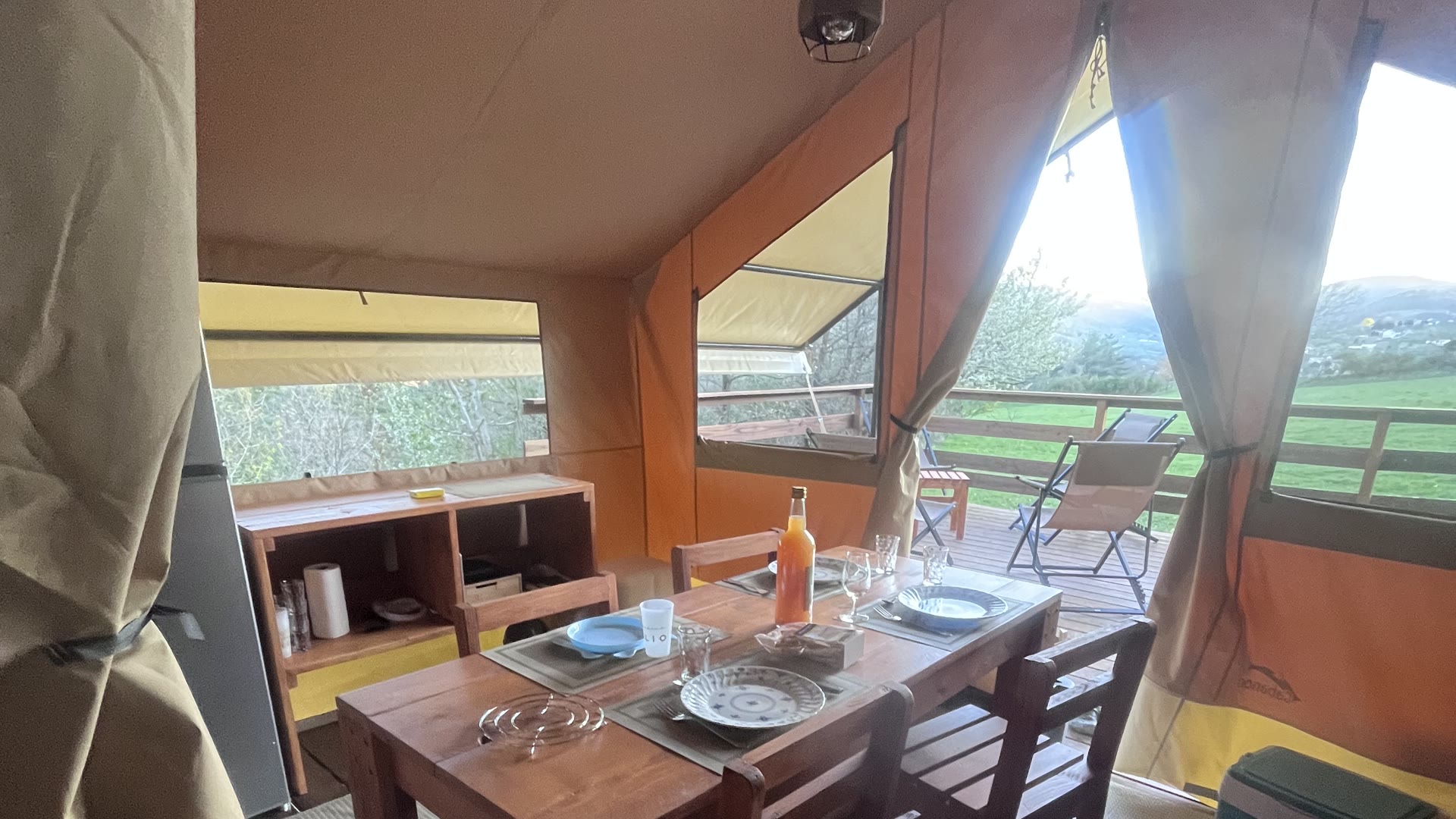 Table en bois dressée dans la tente safari du Domaine Solio, ouverte sur la terrasse