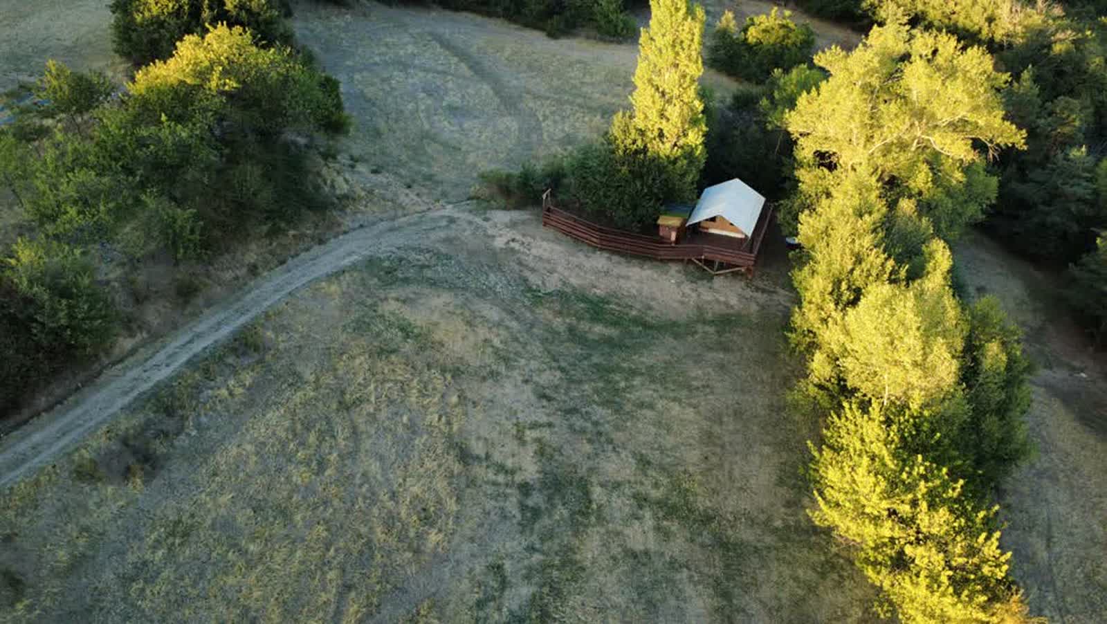 L'Estiva vue du ciel, seule au monde dans son écrin d'arbres dorés