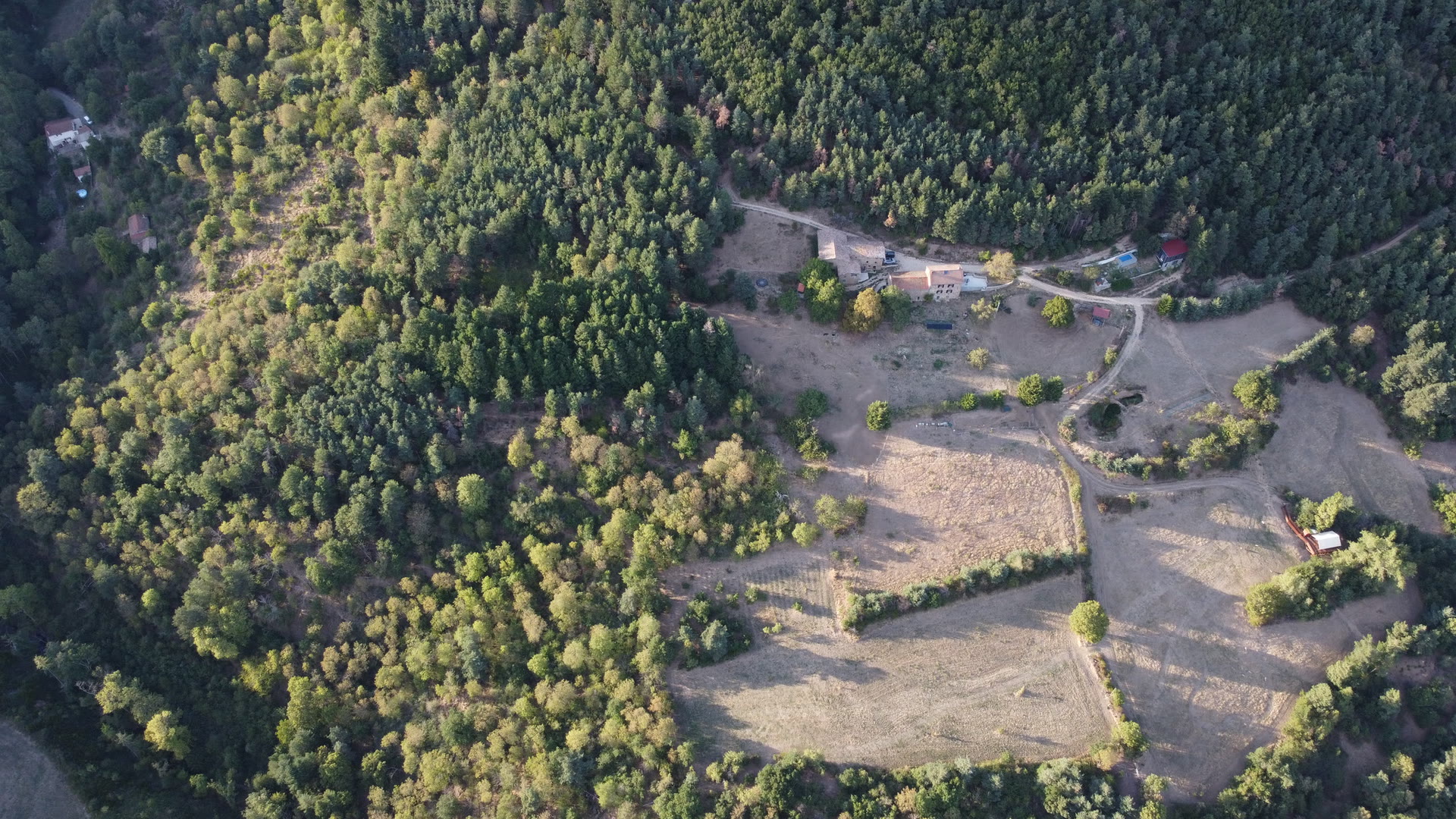 Vue aérienne haute du Domaine Solio : la bâtisse, les prairies et la forêt, l'Estiva isolée sur la droite