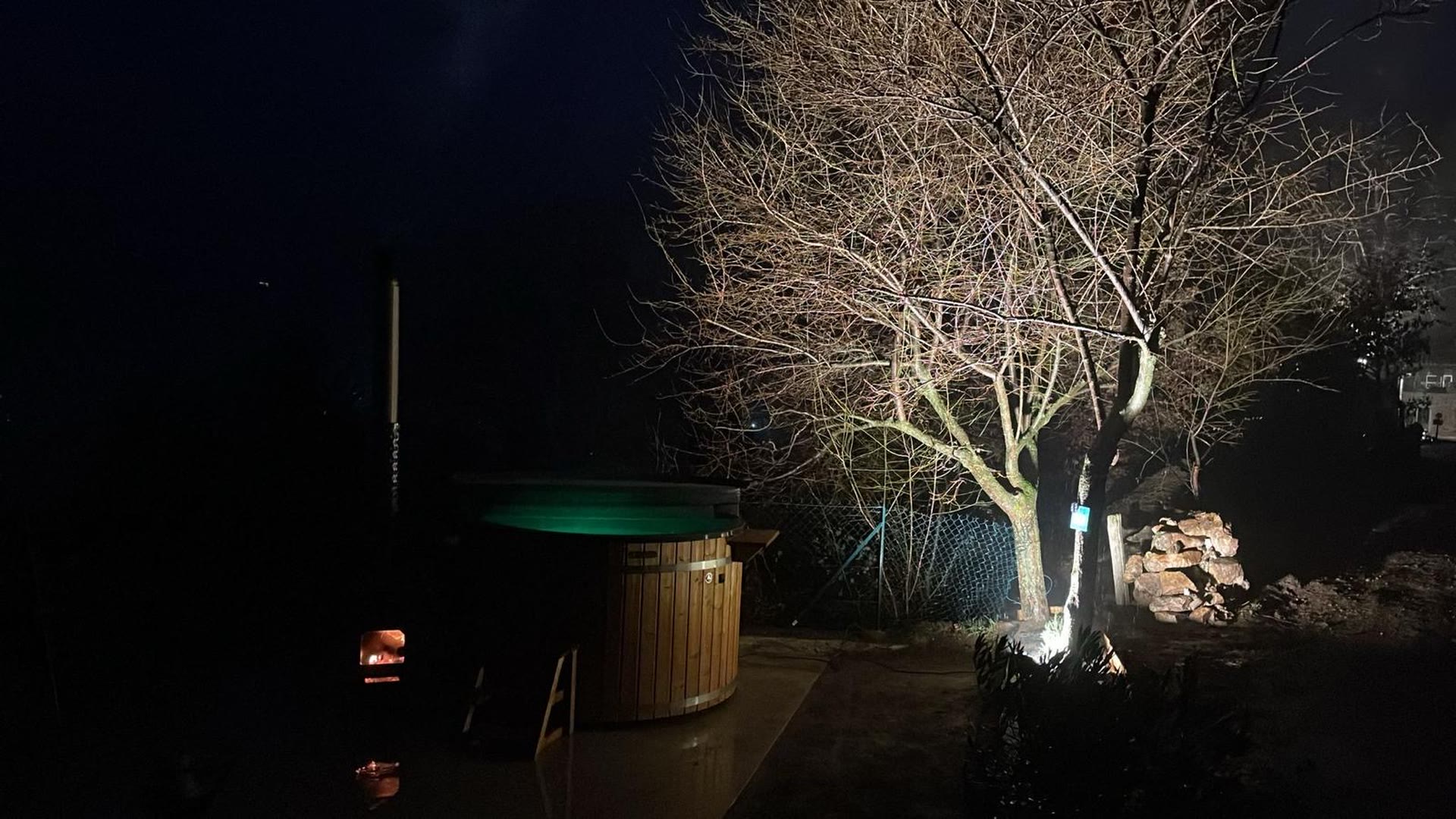 Bain nordique en bois éclairé et chauffé au bois, de nuit, au Domaine Solio