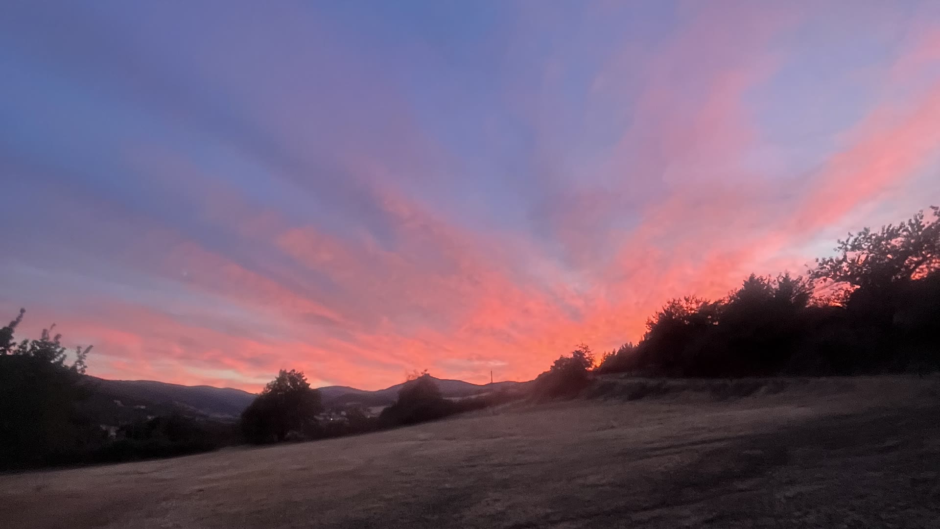 Ciel embrasé de rose au crépuscule au-dessus des collines de l'Ardèche verte, vu du Domaine Solio